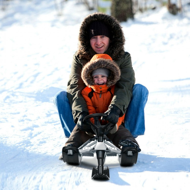 father and son playing in the snow with a sled