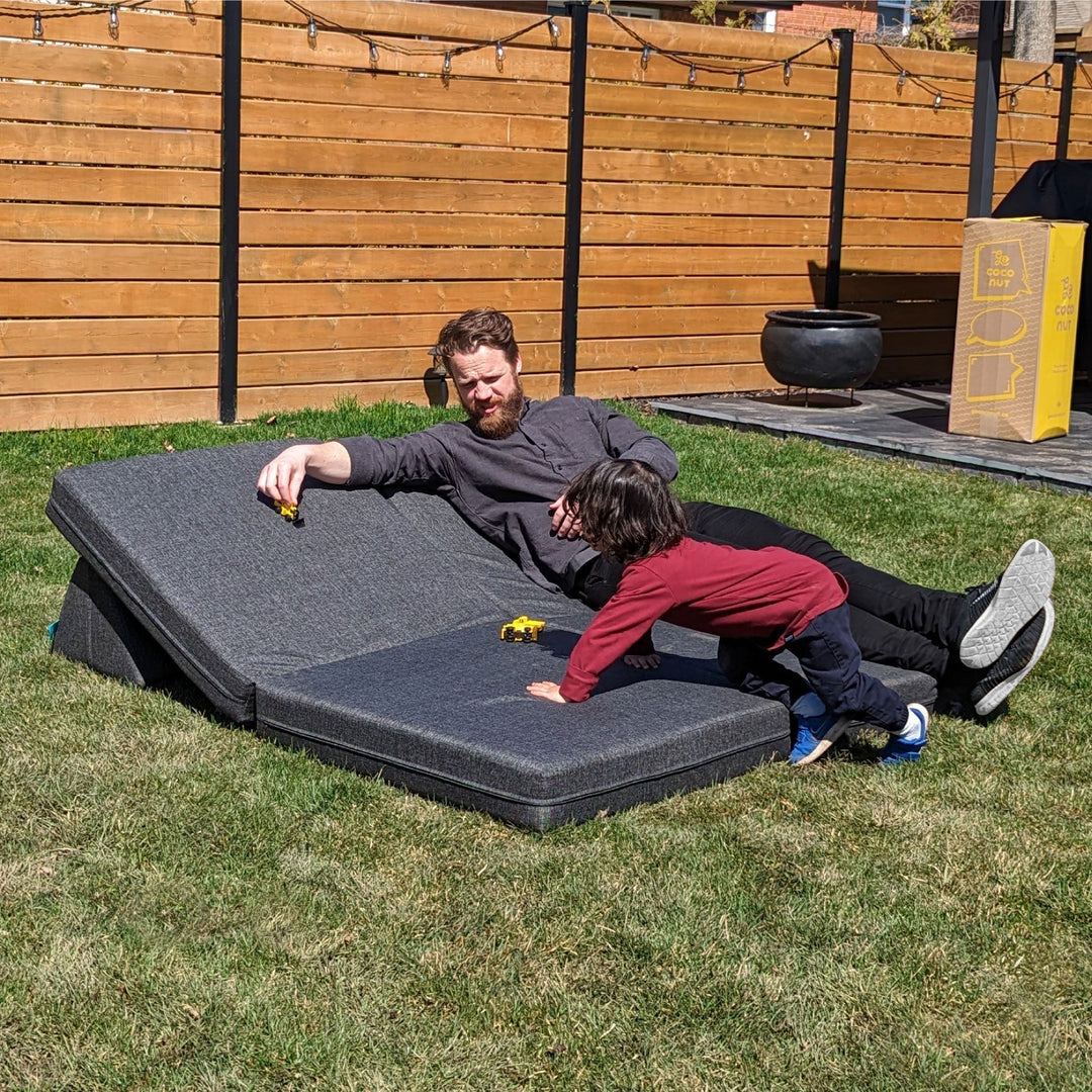 father and son playing the in backyard with modular outdoors grey play couch