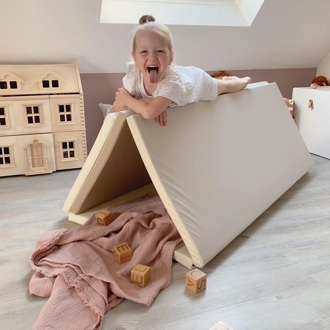 toddler playing with a cream haus play mat