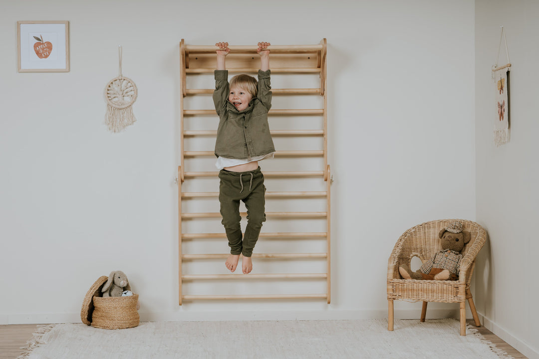 kid climbing on a wooden pikler triangle